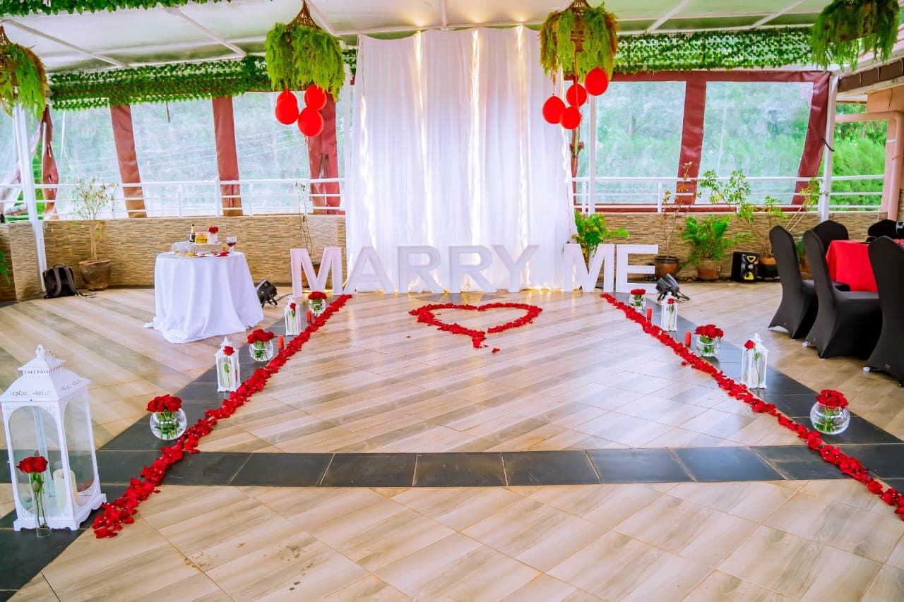 Marry Me letters at the end of a rose petal aisle