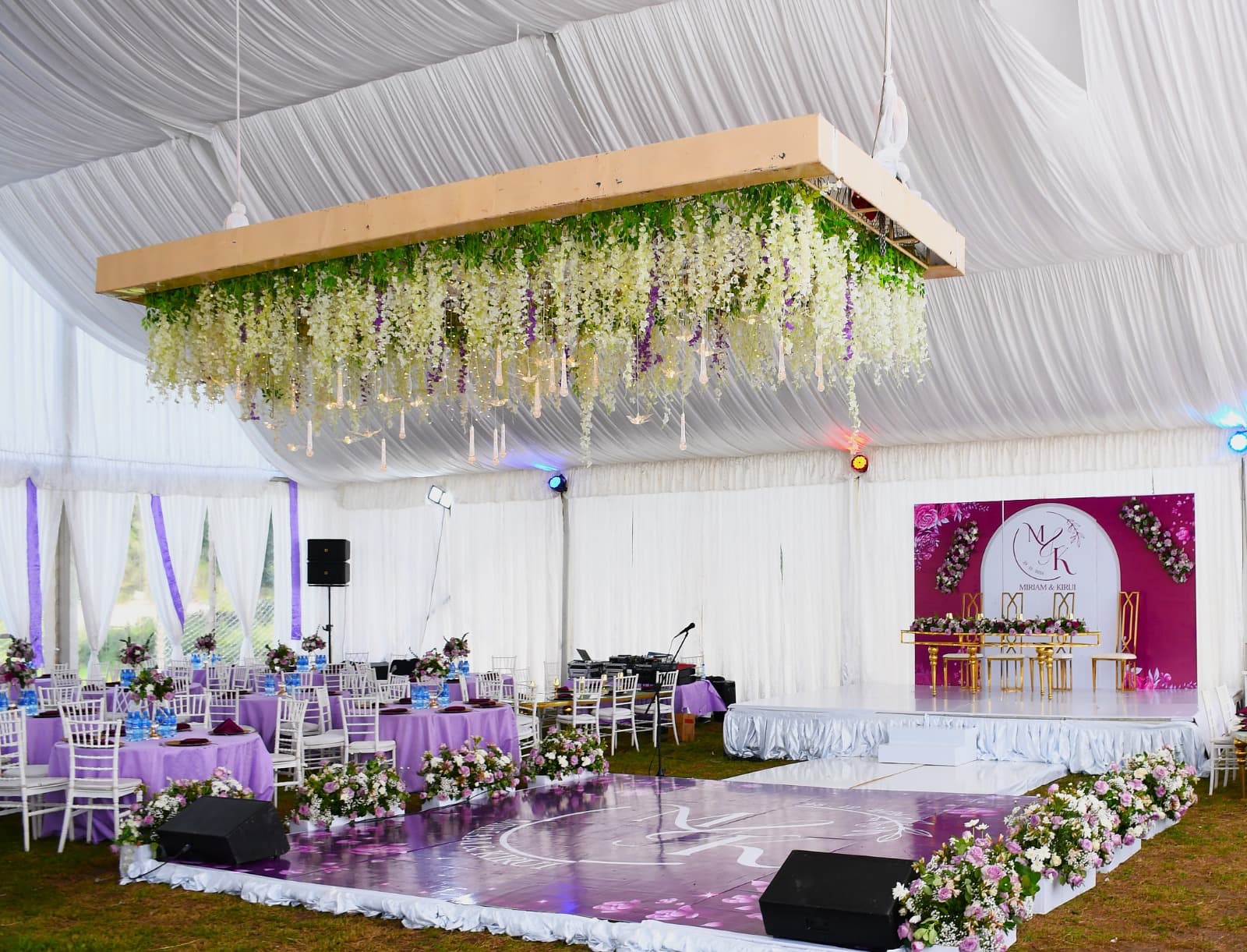 Reception tables in lavender under hanging greenery